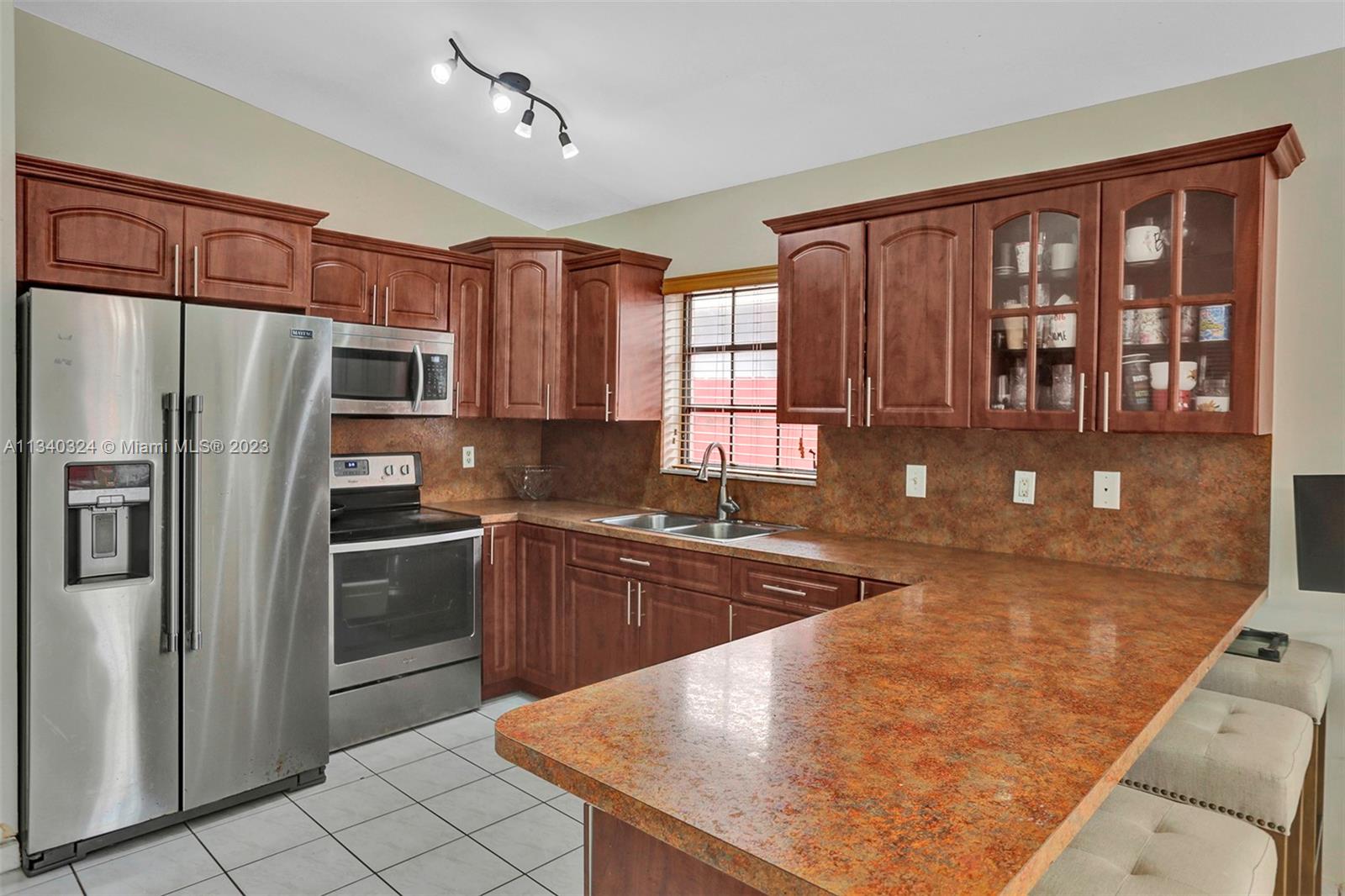 2574 West 71st Place Hialeah, FL 33016 - Photo 3 of 48 a kitchen with stainless steel appliances granite countertop a refrigerator a stove top oven and a sink with granite countertops