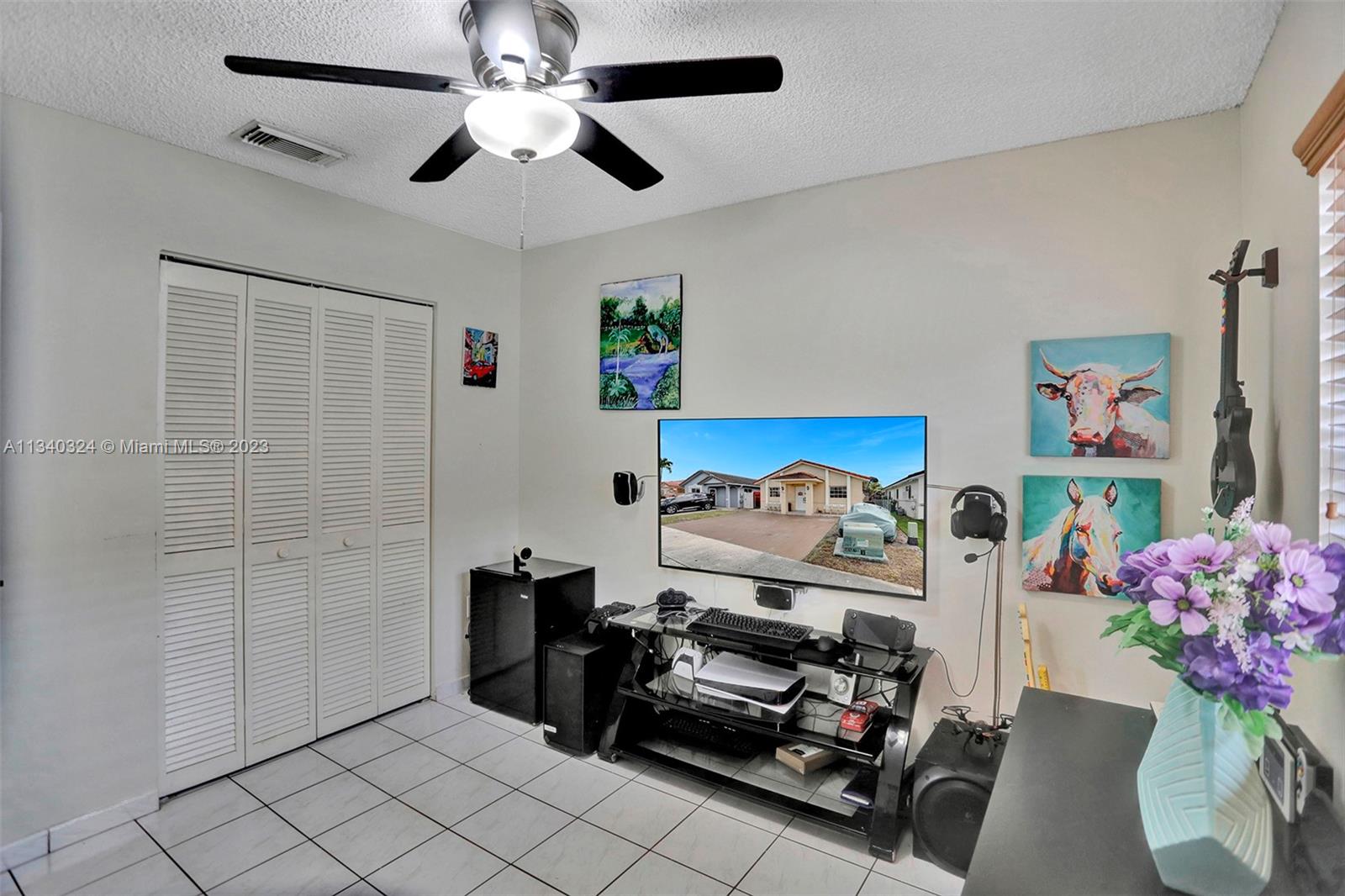 2574 West 71st Place Hialeah, FL 33016 - Photo 35 of 48 a bedroom with furniture and a chandelier