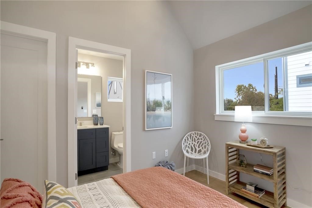 1118 Stobaugh Street, Unit B Austin, TX 78757 - Photo 4 of 12 a bedroom with a bed and a chandelier