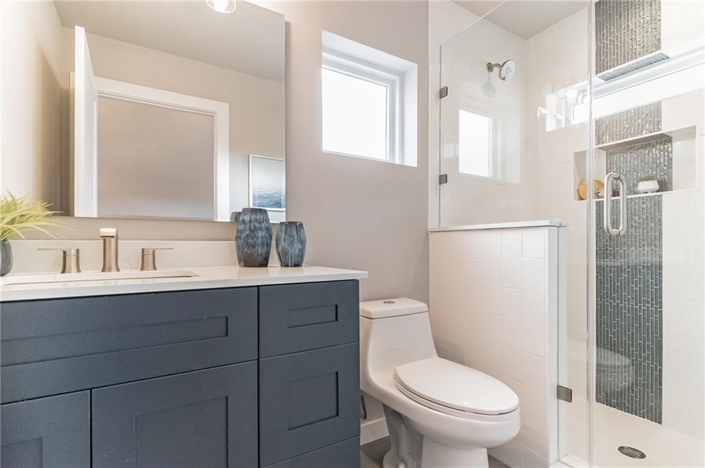 1118 Stobaugh Street, Unit B Austin, TX 78757 - Photo 5 of 12 a bathroom with a toilet a sink and a mirror