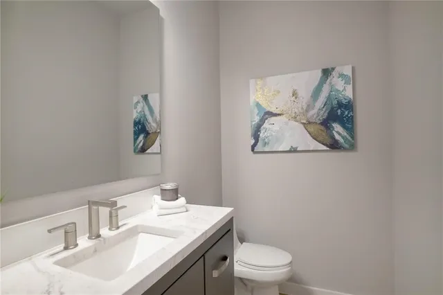 a bathroom with a granite countertop sink mirror and toilet