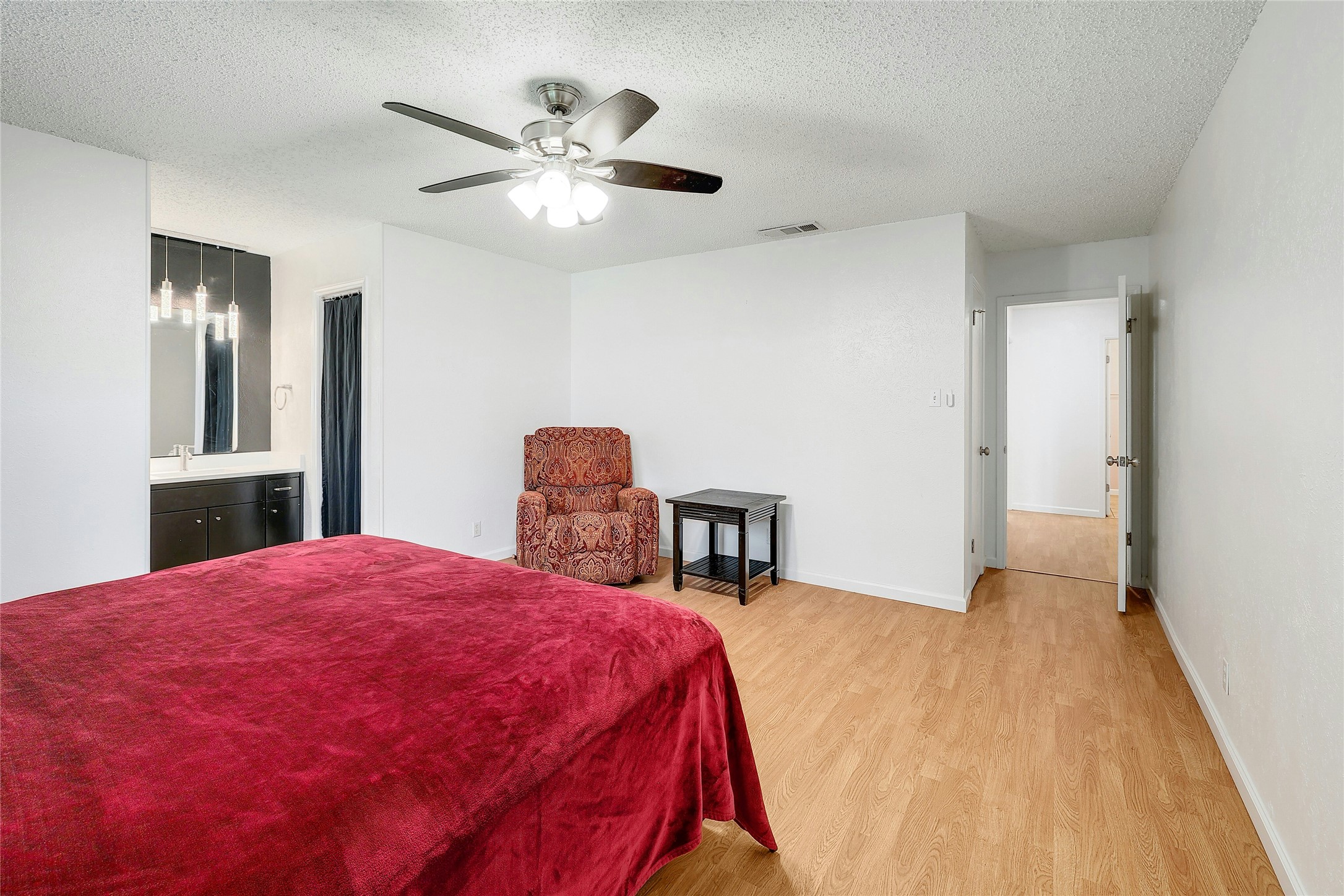 11720 Running Fox Trail Austin, TX 78759 - Photo 18 of 31 a spacious bedroom with a bed and a chandelier
