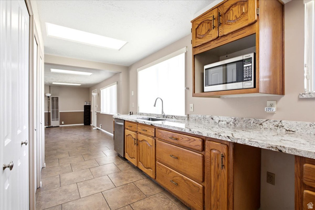 7050 South 260 East Midvale, UT 84047 - Photo 9 of 28 Kitchen featuring wood cabinetry, a stainless steel dishwasher, and a built-in microwave