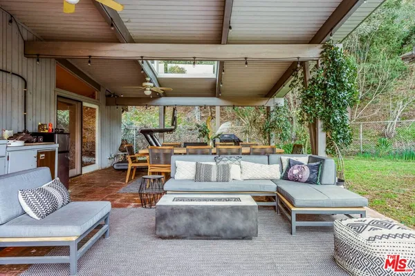a living room with patio furniture and a garden