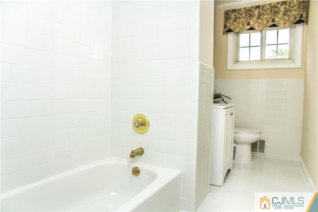 5 Brandeis Road Old Bridge, NJ 08859 - Photo 14 of 25 a bath tub sitting next to a white toilet and a window
