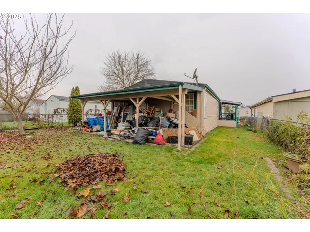 a view of a house with a big yard and large tree