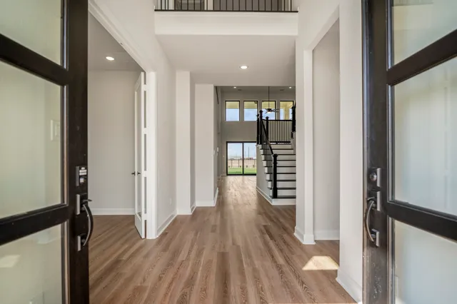 a view of a hallway with wooden floor and stairs