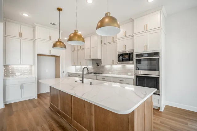 a large kitchen with stainless steel appliances lots of counter space and a sink