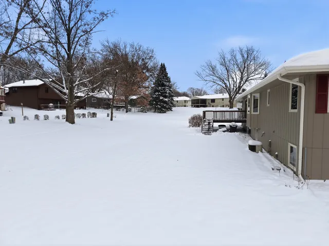 a front view of house with yard and trees in the background