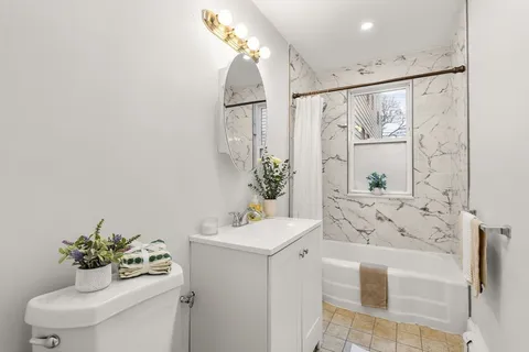 a bathroom with a sink mirror and toilet