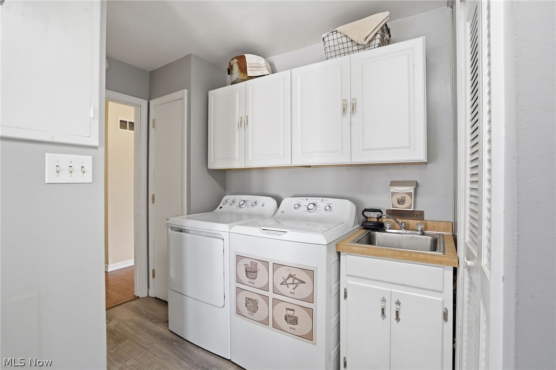 6655 Ceramic Road Crooksville, OH 43731 - Photo 24 of 34 Laundry area featuring light wood-type flooring, cabinet space, and washing machine and clothes dryer