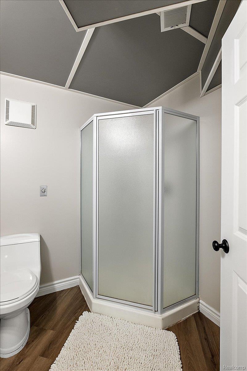 4219 Gardner Road Metamora, MI 48455 - Photo 50 of 84 Corner shower enclosure with frosted glass panels, wood-finish flooring, white baseboards, and a contemporary gray ceiling with white trim