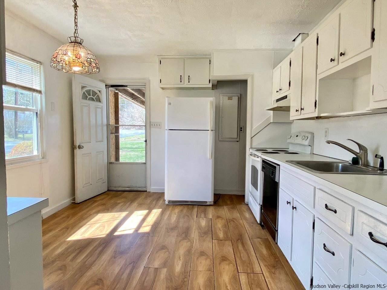 5 South Road, Unit HIGH FALLS PARK High Falls, NY 12440 - Photo 4 of 14 a kitchen with granite countertop a refrigerator a sink dishwasher a stove and white cabinets with wooden floor