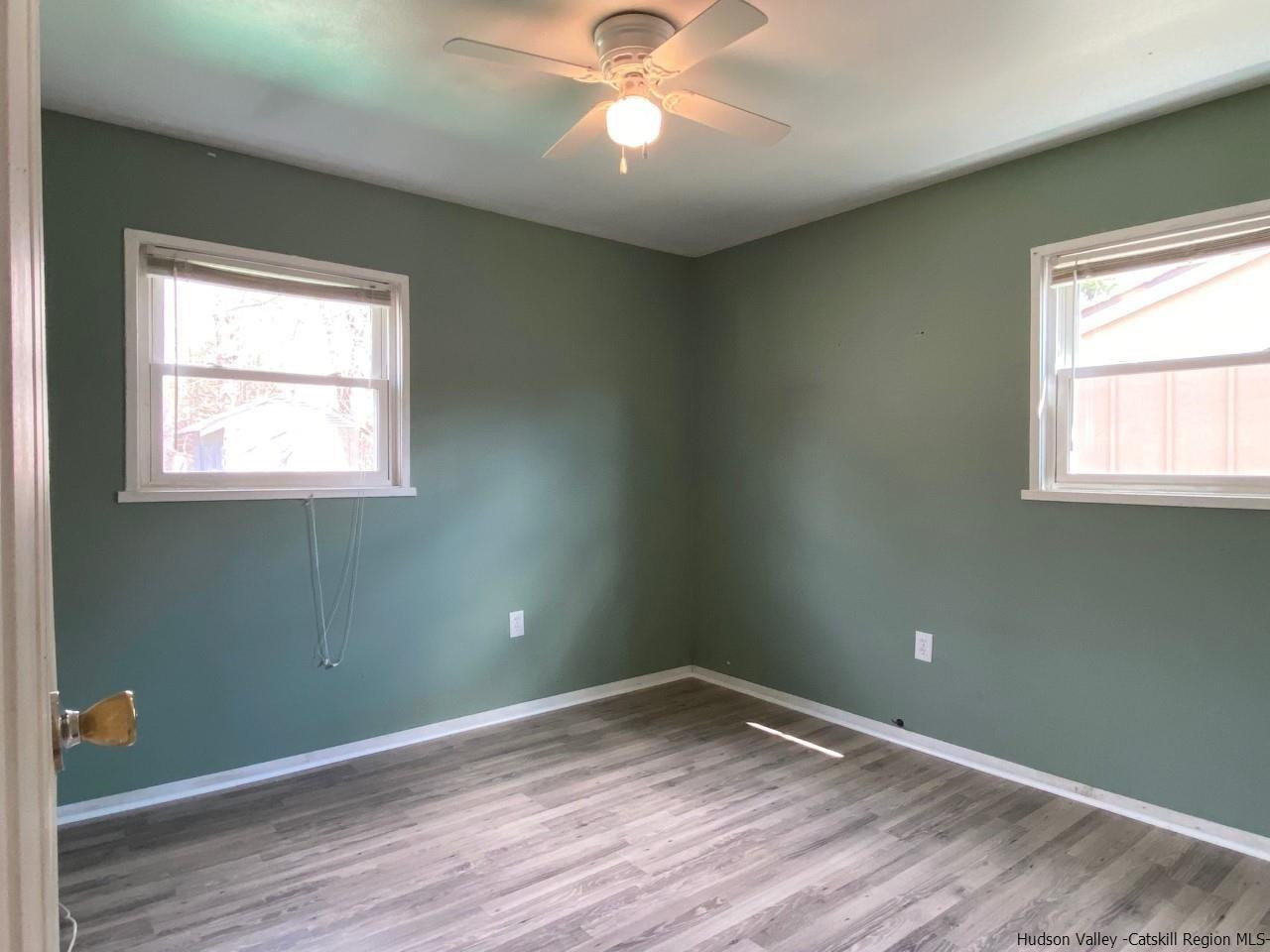 5 South Road, Unit HIGH FALLS PARK High Falls, NY 12440 - Photo 8 of 14 an empty room with wooden floor a chandelier fan and windows