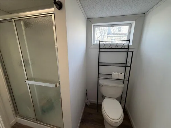 a white toilet sitting next to a shower