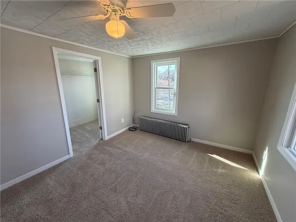 an empty room with a fan and a window