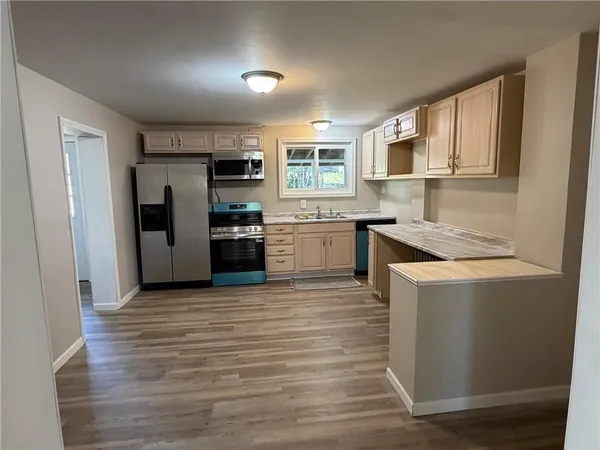 a kitchen with stainless steel appliances granite countertop a refrigerator and a stove top oven