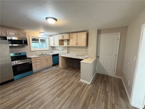 a kitchen with a sink and wooden floor