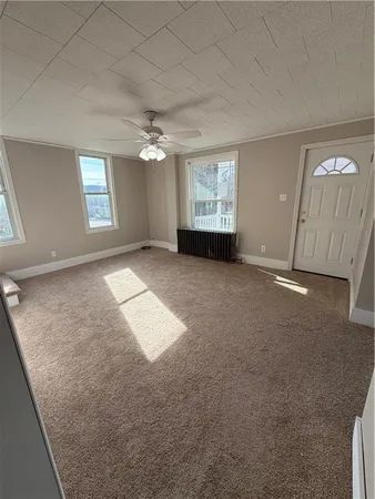 an empty room with windows and fireplace