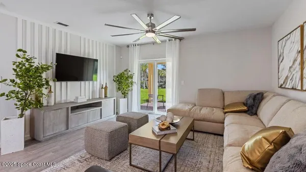 a living room with furniture a flat screen tv and a large window
