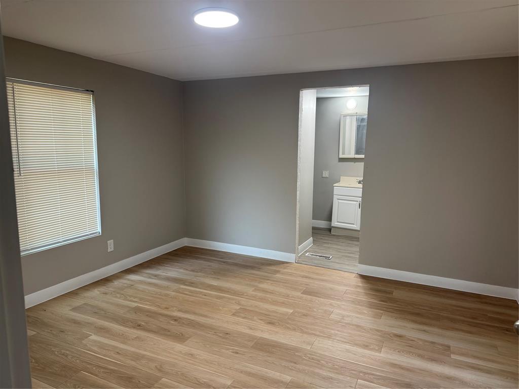 117 Aztec Way West Tawakoni, TX 75474 - Photo 6 of 12 Room featuring wood-finish flooring, neutral wall tones, and bright overhead lighting