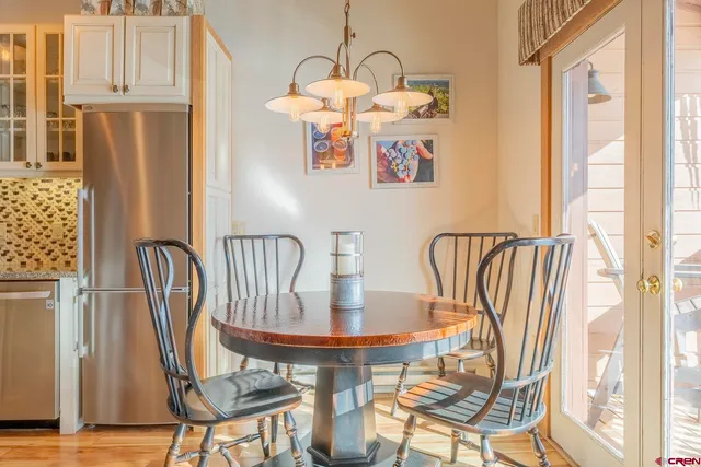 a dining room with furniture a chandelier and wooden floor