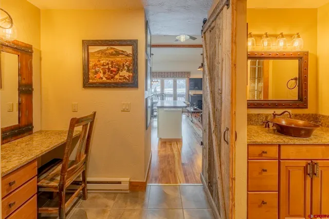 a view of a hallway with a dining table and chairs