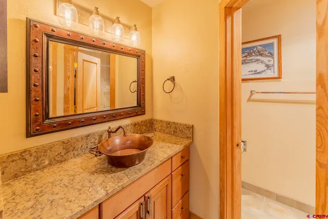 a bathroom with a granite countertop sink and a mirror