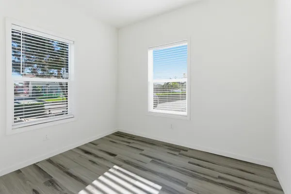 a view of a room that has a window and wooden floor
