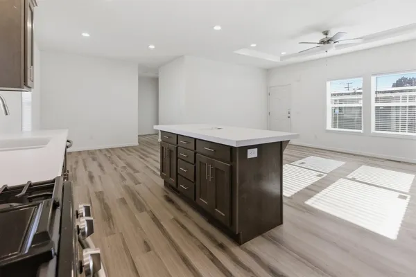 a kitchen with a stove a sink and wooden floor