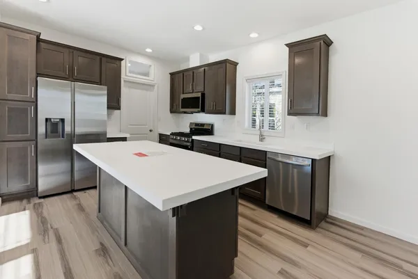 a large kitchen with a sink and stainless steel appliances