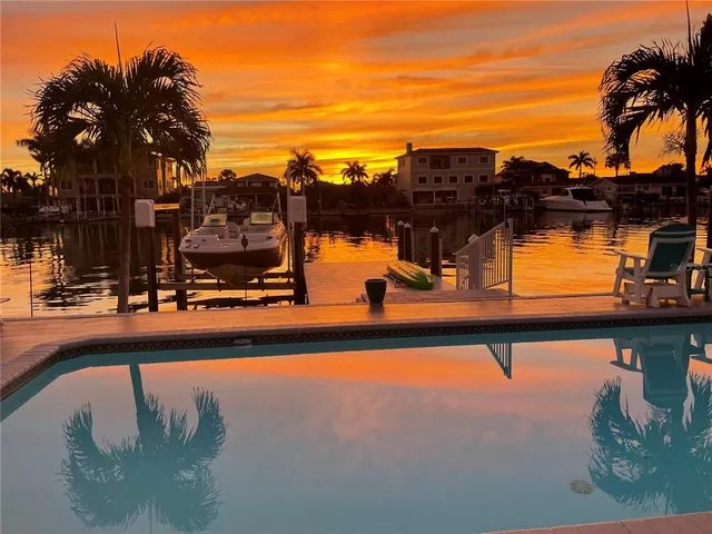a dining room with wooden floor a chandelier a wooden table and chairs