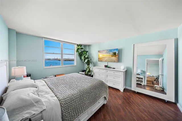 a bedroom with a bed and a large window