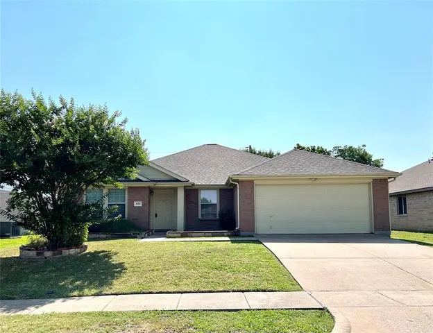 a front view of a house with a garden and yard