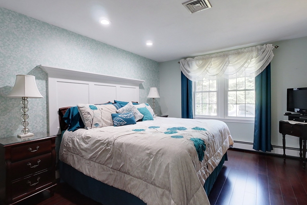 120 1/2 Lowell Road, Unit A Pepperell, MA 01463 - Photo 11 of 30 a bedroom with a large bed and a flat tv screen on dresser