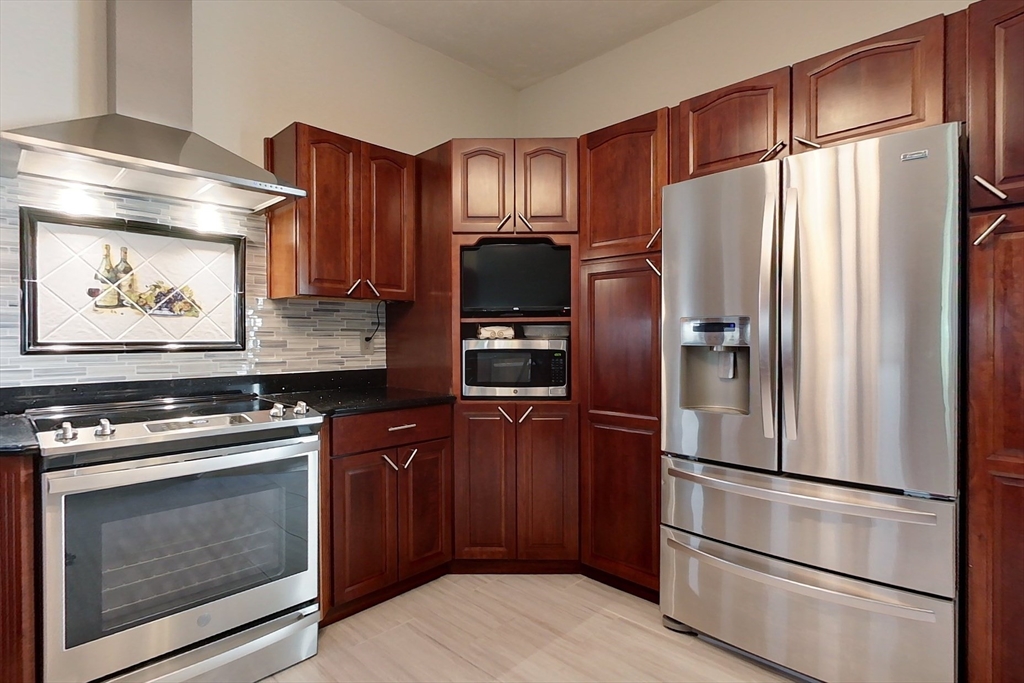 120 1/2 Lowell Road, Unit A Pepperell, MA 01463 - Photo 5 of 30 a kitchen with stainless steel appliances wooden floor sink and wooden cabinets