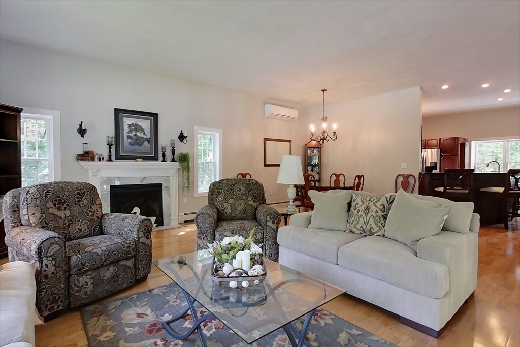 120 1/2 Lowell Road, Unit A Pepperell, MA 01463 - Photo 8 of 30 a living room with furniture a fireplace and a chandelier