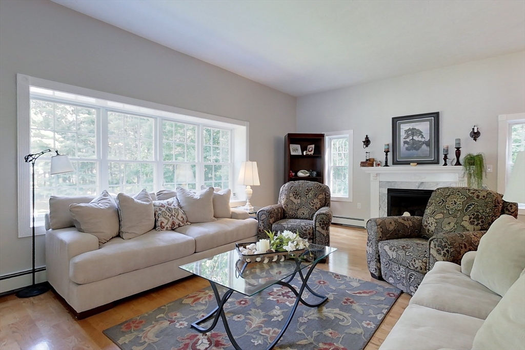 120 1/2 Lowell Road, Unit A Pepperell, MA 01463 - Photo 9 of 30 a living room with furniture a large window and a fireplace