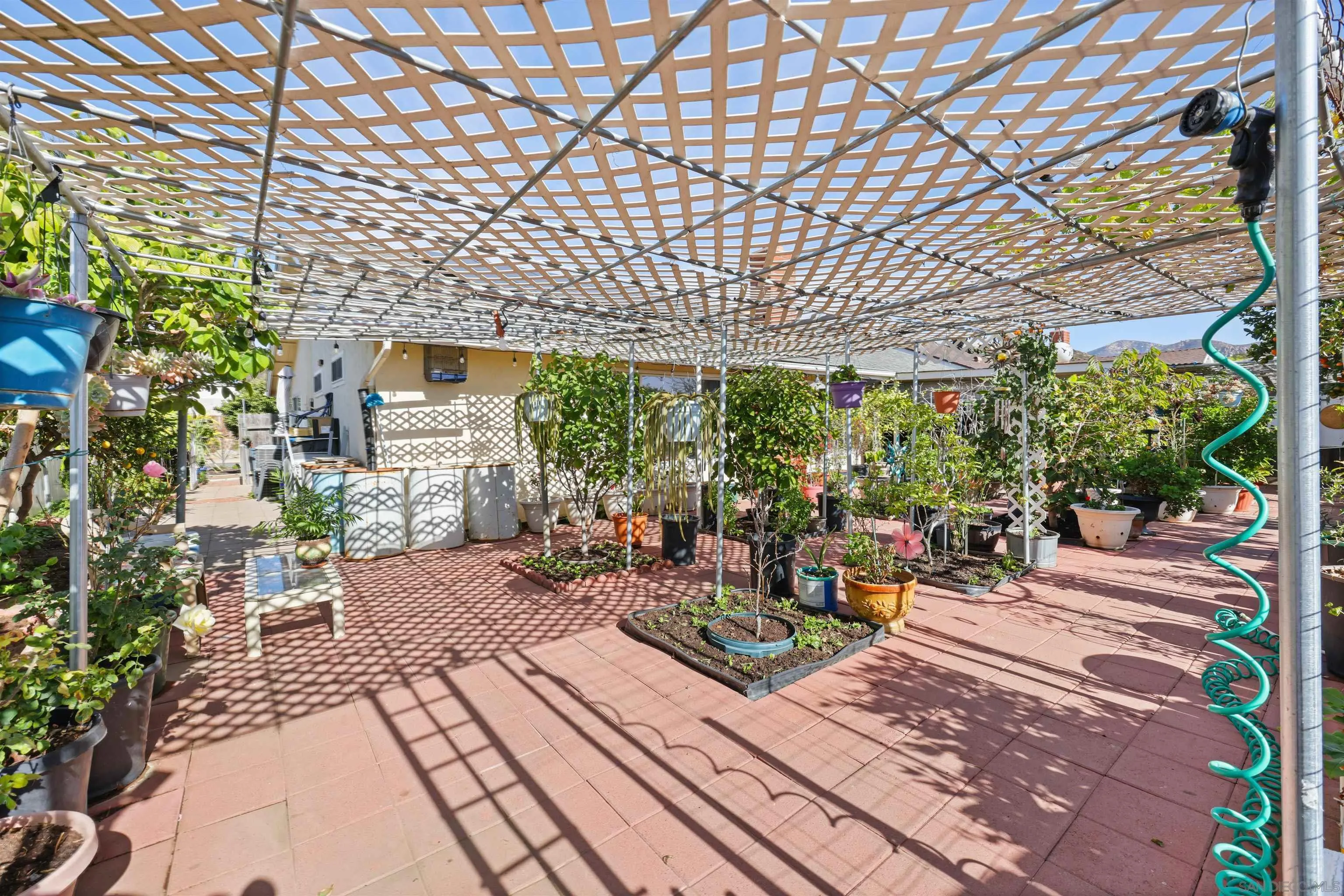 14513 Mirando Street Poway, CA 92064 - Photo 12 of 25 a view of a patio with table and chairs potted plants and large tree