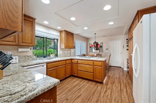 a kitchen with granite countertop wooden cabinets a sink and a window