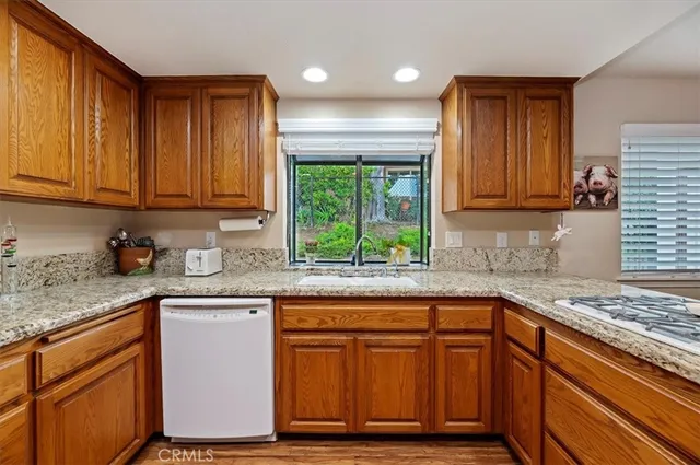 a kitchen with granite countertop a refrigerator and cabinets