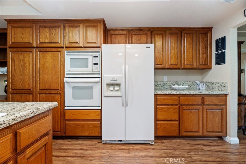 1168 North Crescent Ridge Road Fallbrook, CA 92028 - Photo 16 of 45 a kitchen with granite countertop a refrigerator and cabinets