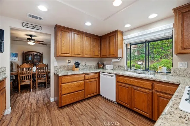 a kitchen with stainless steel appliances granite countertop a refrigerator a stove top oven a sink and dishwasher