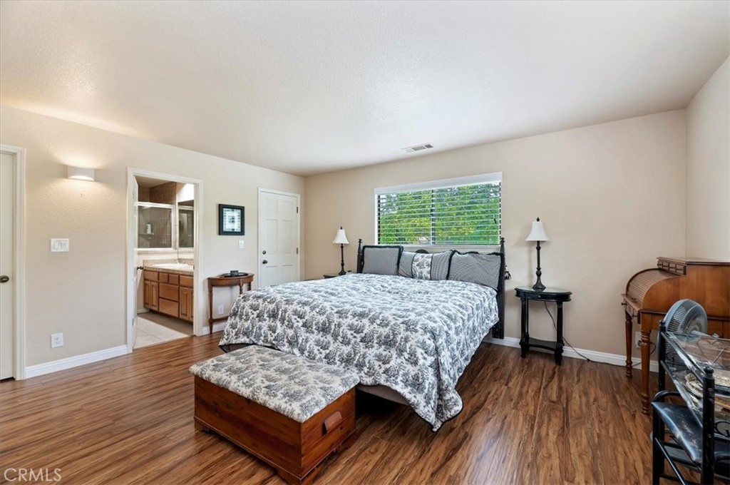 1168 North Crescent Ridge Road Fallbrook, CA 92028 - Photo 27 of 45 a bedroom with a bed and wooden floor