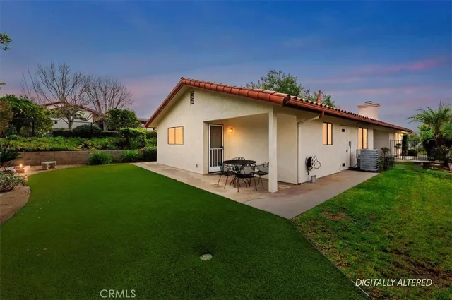 a view of a house with backyard and sitting area
