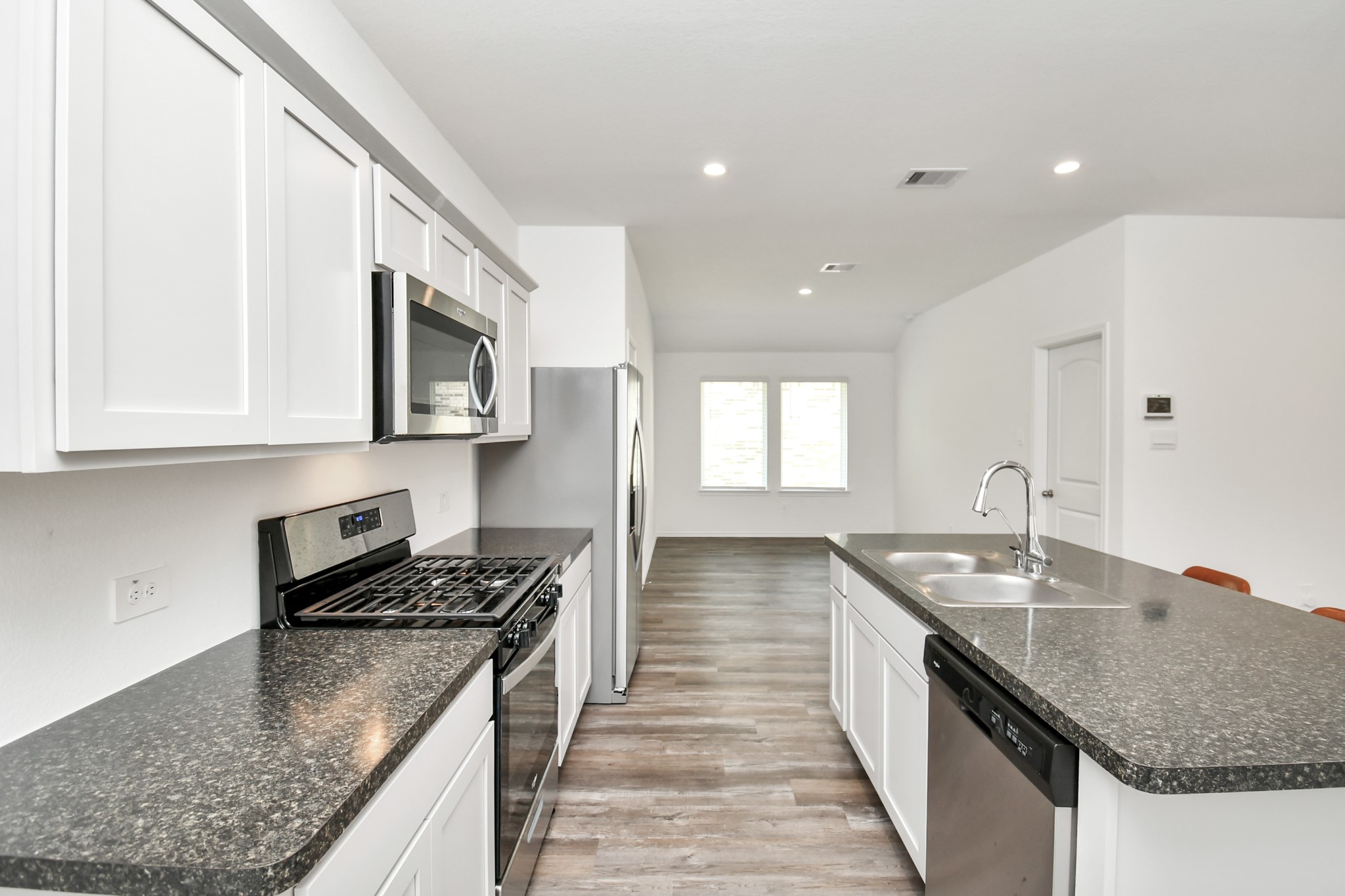 5315 Castlebury Meadows Dr Spring Spring, TX 77373 - Photo 6 of 39 a kitchen with stainless steel appliances granite countertop a sink stove microwave and cabinets