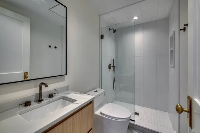 a bathroom with a granite countertop sink toilet and shower