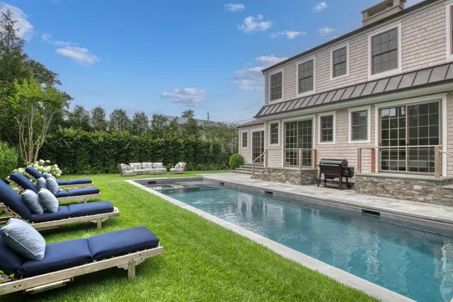 a view of a house with swimming pool and sitting area