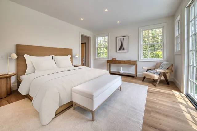 a spacious bedroom with a bed and glass window