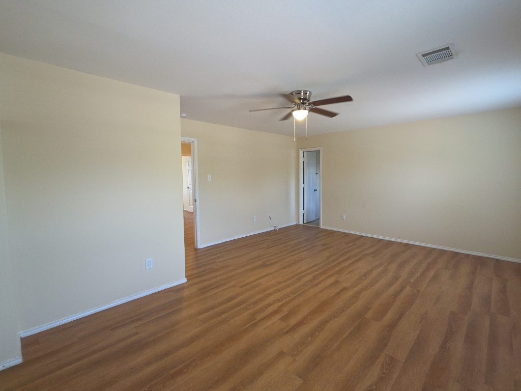 204 Ruby Lake Drive Kyle, TX 78640 - Photo 11 of 22 Empty room with dark wood finished floors and ceiling fan